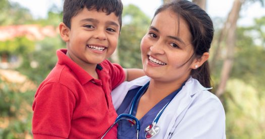 Portrait of a happy child being held by his pediatrician. Portrait of a smiling doctor and child.