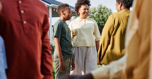 Side view of big African American family chatting outdoors during Summer party outdoors