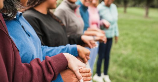 Women's circle during a group yoga class with people of different age and body types - Healthy lifestyle, female connection and meditation concept - Main focus on close up hand